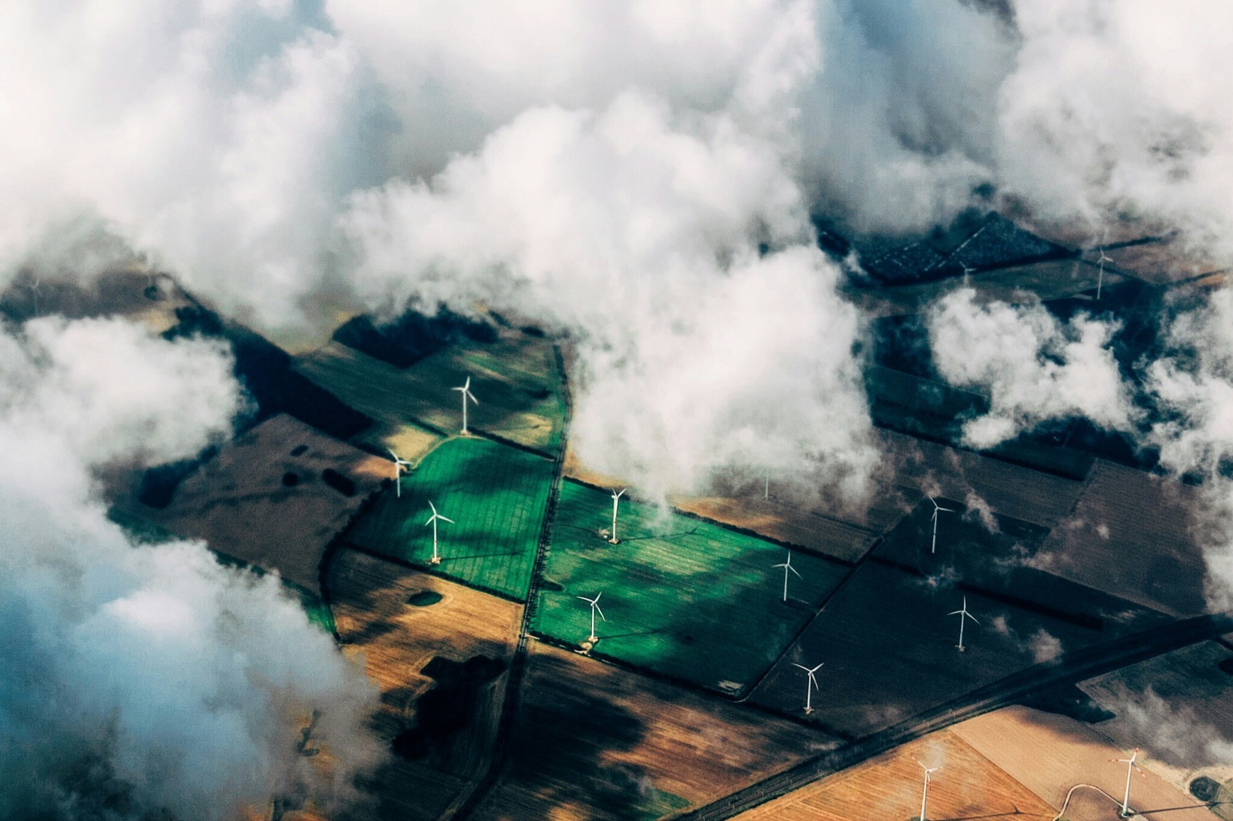 Wind turbines seen through clouds from above